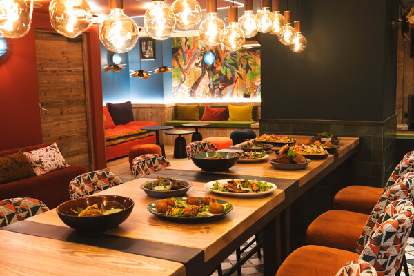 Salle du Semba avec une longue table garnie de plats à partager