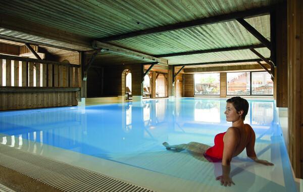 Piscine intérieure du spa sous une charpente en bois