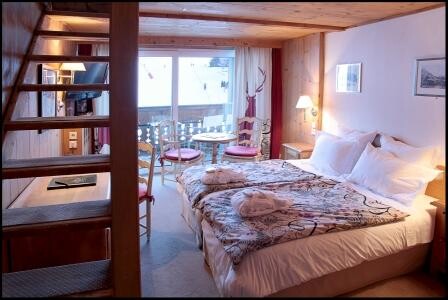 Chambre Chalet sur deux niveaux avec lit double et escalier en bois